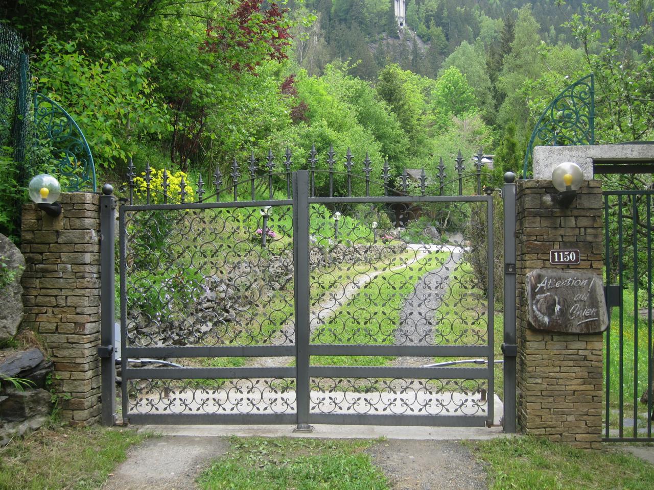 Portail en fer forgé qui ouvre sur le jardin